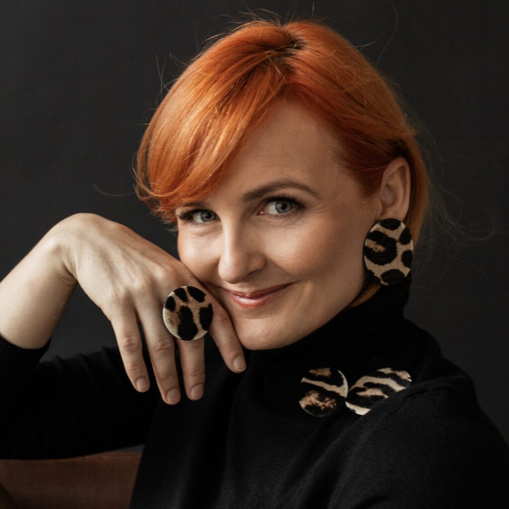 Kobieta prezentująca ręcznie robioną biżuterię Made By Mila — kolczyki i pierścionek w animal print, elegancka sesja wizerunkowa.