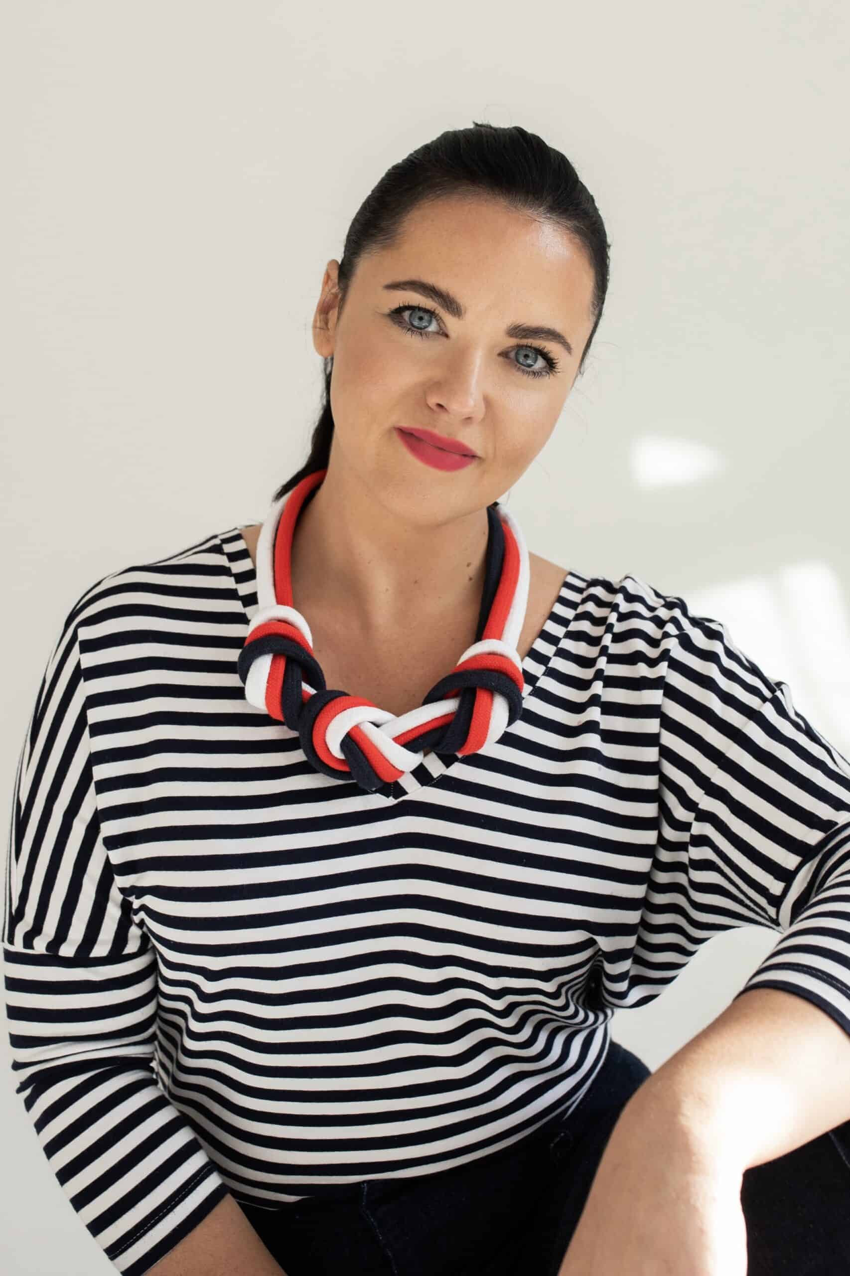 Modelka w pasiastym topie w naszyjniku TRIO: czerwień, biel, granat